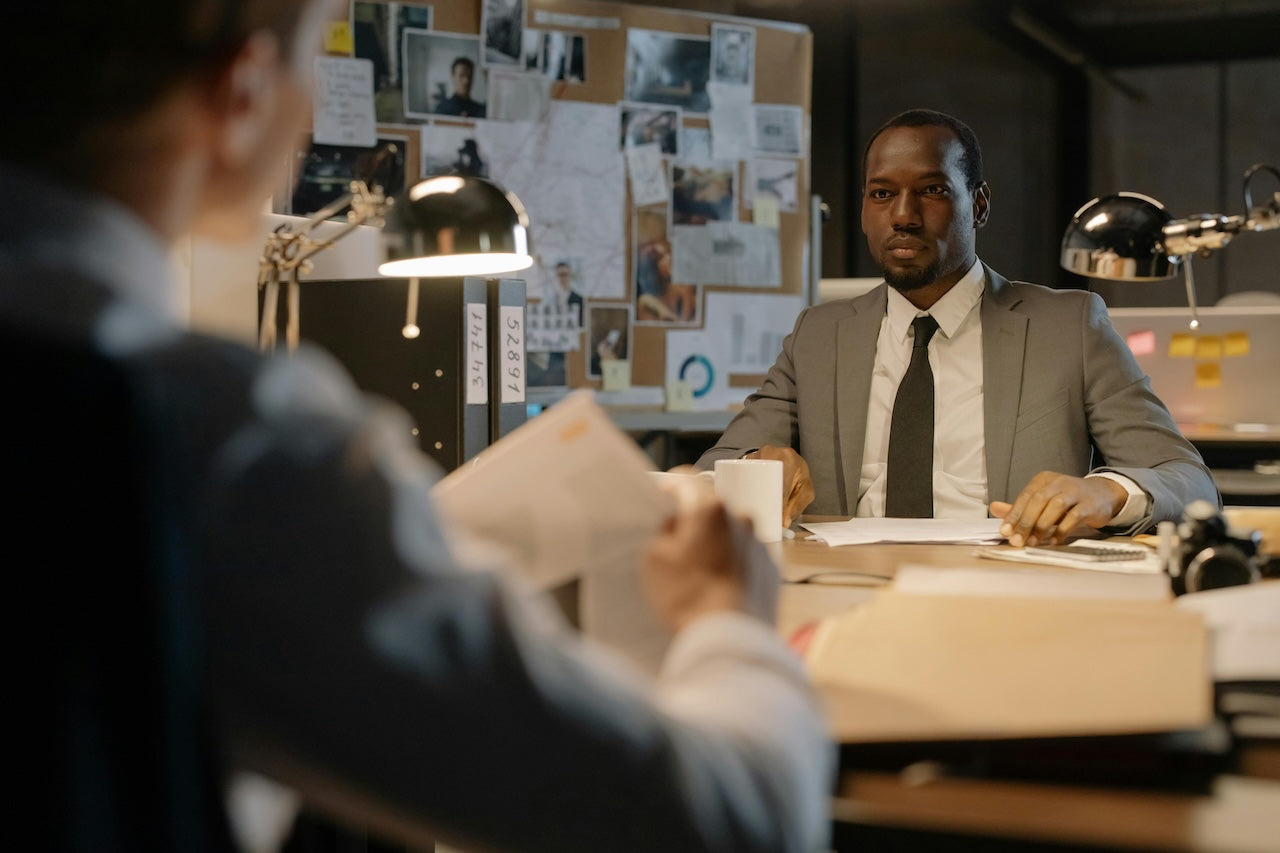 two private investigators at a desk