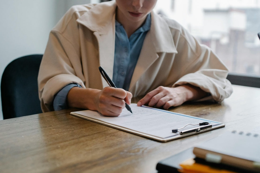 woman filling out a form at desk